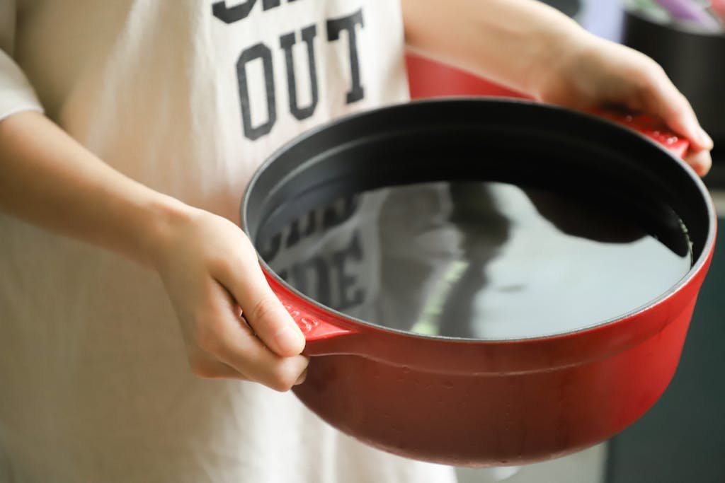 Close-up of hands holding a red pot filled with water, indoors.

budget Amazon slow cookers